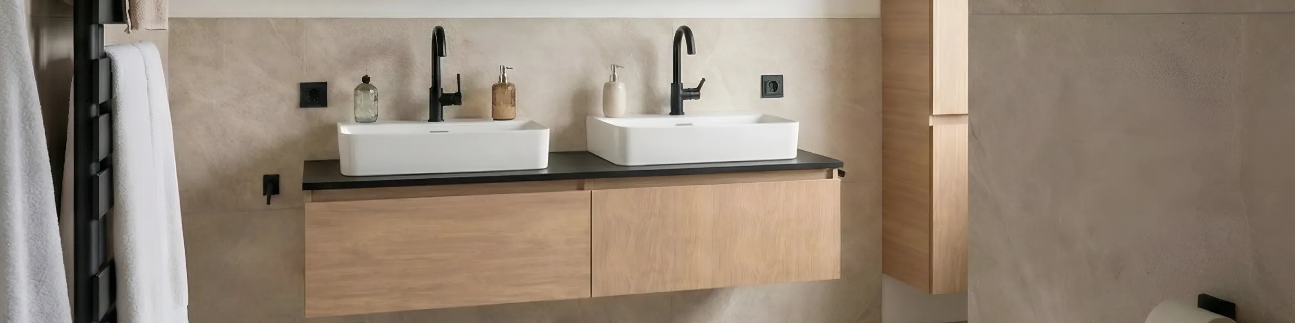 Duschbad in warmen Naturtönen mit Doppelwaschtisch, schwarzen Armaturen und Holzunterschrank auf heller Natursteinfliese.