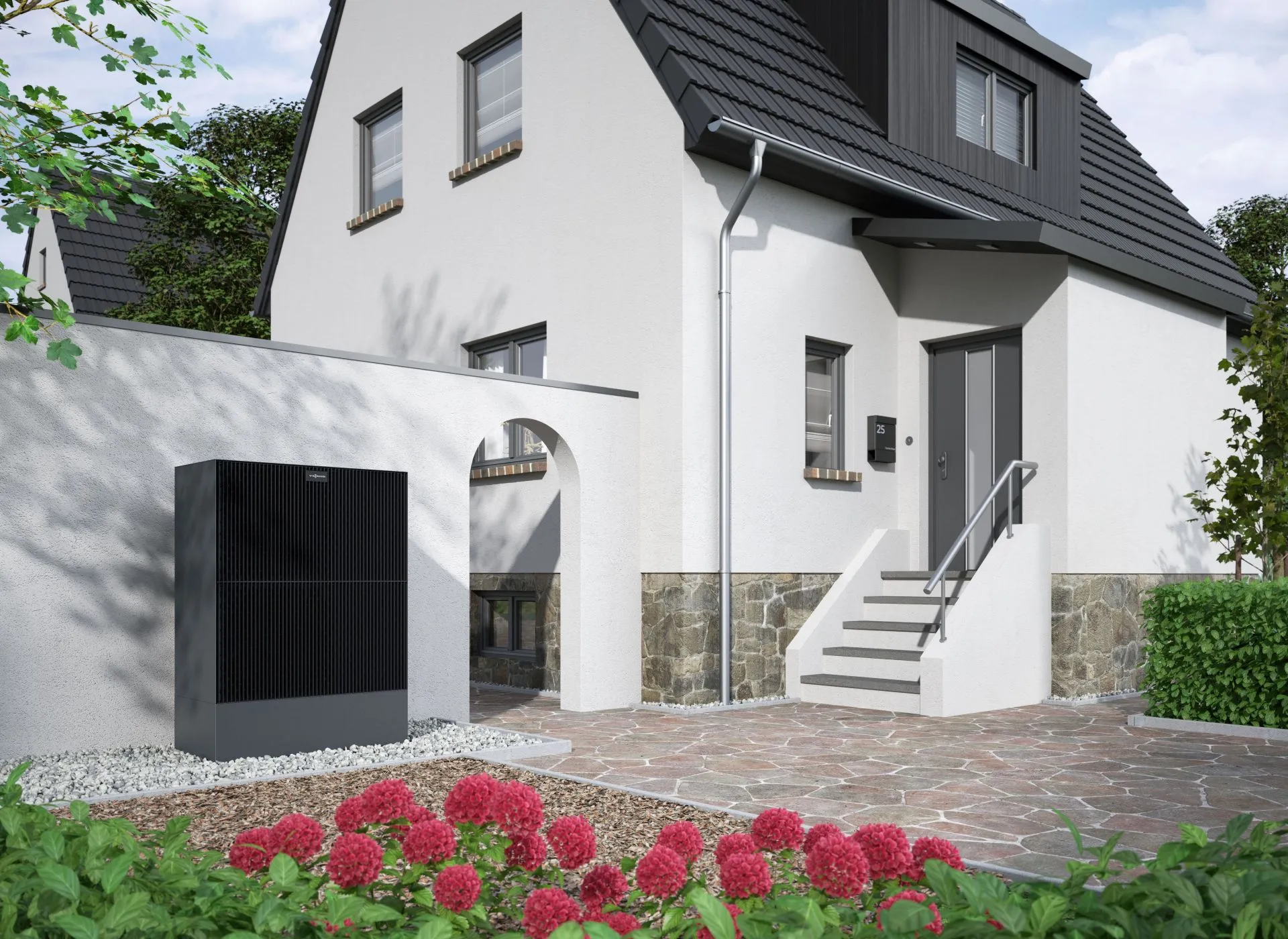 Wärmepumpe von Viessmann steht vor einem Altbau auf einem Kiesbett.