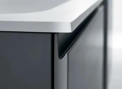 Detailansicht eines Stocco Badmöbels mit integrierter Griffleiste, matter Front und weißer Waschtischplatte.