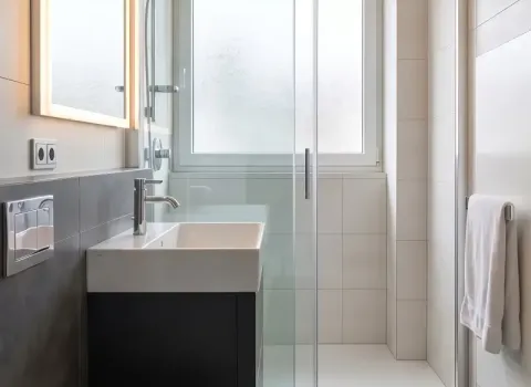 Duschbad mit bodengleiche Dusche, Fenster und minimalistischer Gestaltung