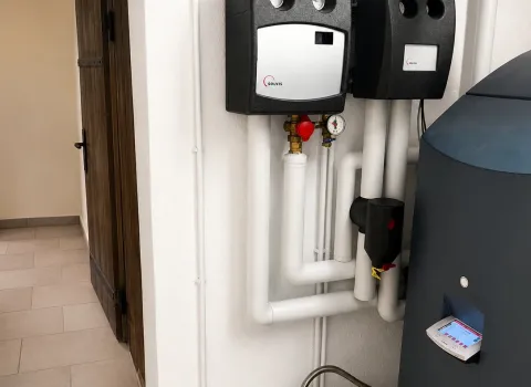 Eine Heizungsinstallation mit Solvis Hydraulikstation, Pufferspeicher und gedämmten Heizungsleitungen befindet sich in einem historischen Keller. Die sauber montierten Komponenten gewährleisten eine effiziente Wärmeverteilung und einen energiesparenden Betrieb der Heizungsanlage. Das Bild zeigt eine hochwertige Modernisierung mit zeitgemäßer Heiztechnik.