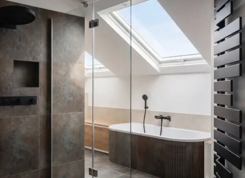 Stilvolles Badezimmer mit Dachschräge, schwarzen Armaturen und Heizkörper