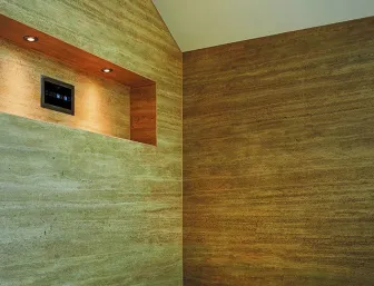 Ein luxuriöses Dampfbad mit Wänden, Boden und Sitzbank aus warmem Naturstein in beige-goldenen Tönen. 