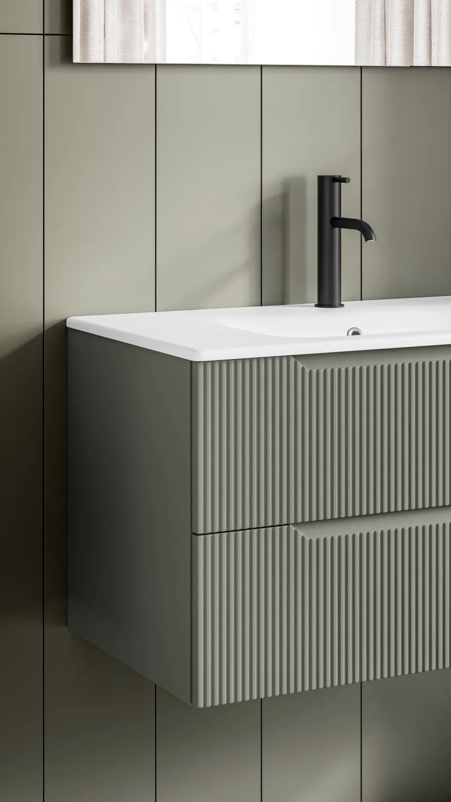 Detailansicht eines wandhängenden Waschtischs mit geriffelter Front in Salbeigrün und schwarzer Armatur.