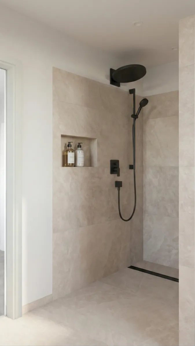 Zeitlose Duschgestaltung mit beigen Fliesen, Regenduschkopf in Schwarz und integrierter Shampoo-Nische.